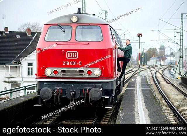 15 November 2023, Lower Saxony, Oldenburg: Roland Sandkuhl, a self-employed train driver from Oldenburg, steps into the driver's cab of his 1965 DB V 169 diesel...