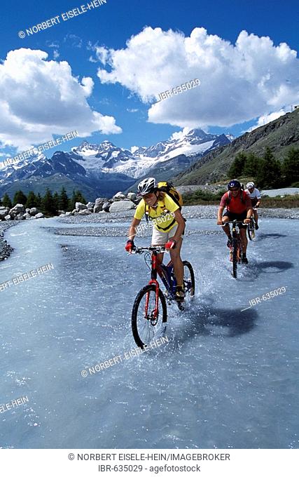 Mountain bikers, Grinjisee Lake, Mt. Zinalrothorn, Zermatt, Valais, Switzerland, Europe