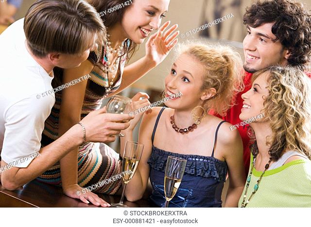 Young people are chatting at an evening-party