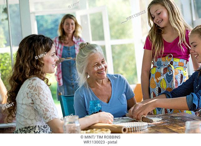 Farmhouse in the country in New York State. Four generations of women in a family baking together