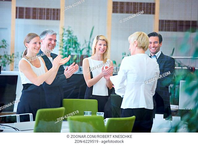 Zufriedene Geschäftsleute im Büro applaudieren nach einer Präsentation