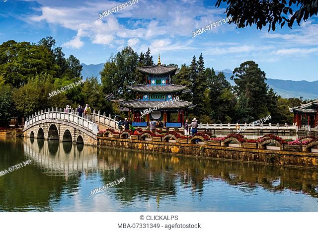 Tourists over arched bridge at Black Dragon Pool, Lijiang, Yunnan Province, China, Asia, Asian, East Asia, Far East