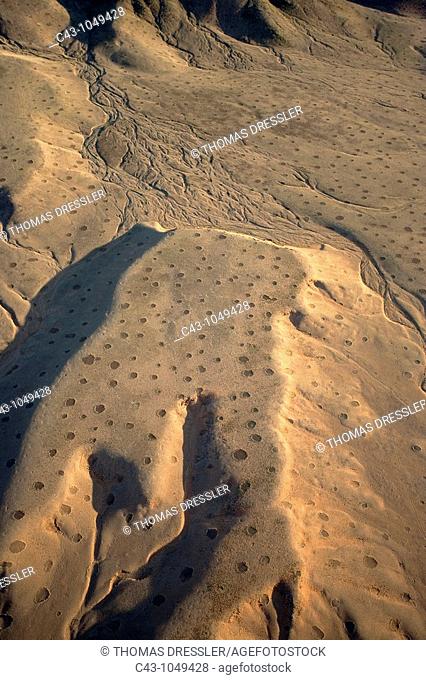 Namibia - Aerial view of arid mountain ridges and dry riverbeds at the edge of the Namib Desert  The so-called 'Fairy Circles' are circular patches without any...