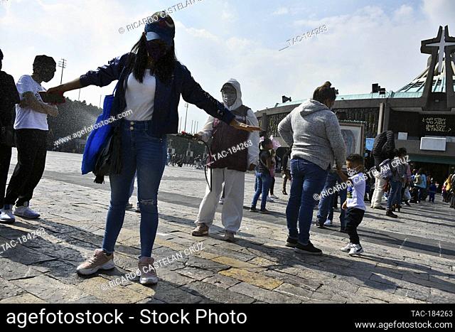 MEXICO CITY, MEXICO - DECEMBER 8: A Faithful is disinfected during her visit of the Basilica of Guadalupe church as part of pilgrimage to celebrates Guadalupe...