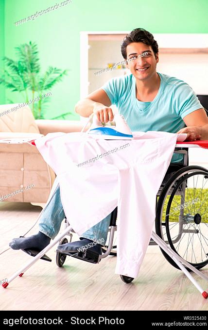 Disabled man on wheelchair ironing clothing