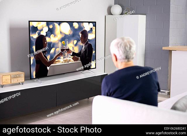 Watching TV Or Television In Living Room At Sofa
