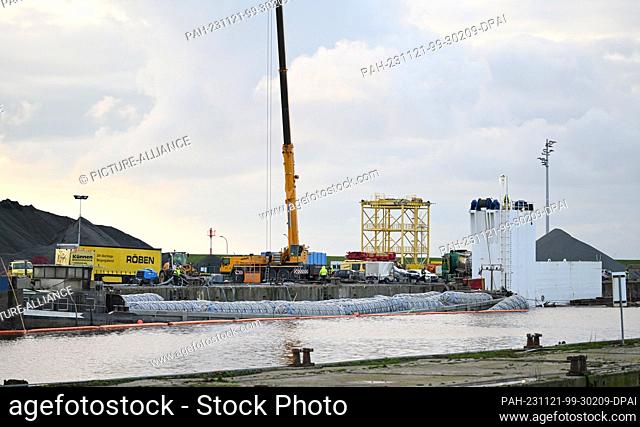 21 November 2023, Lower Saxony, Emden: The inland waterway vessel ""Sabine"", which was lifted with air bags, lies on the Südkai in front of the dock ship ""BHV...