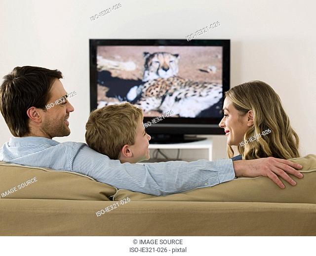 A family watching tv and talking
