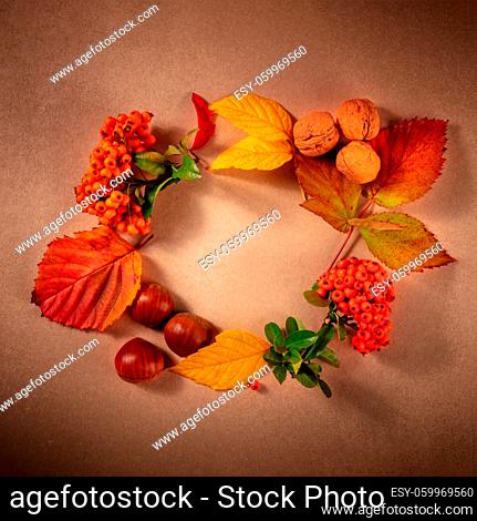 Autumn wreath, square design template with a place for text, autumn leaves flat lay composition, top shot on a brown background