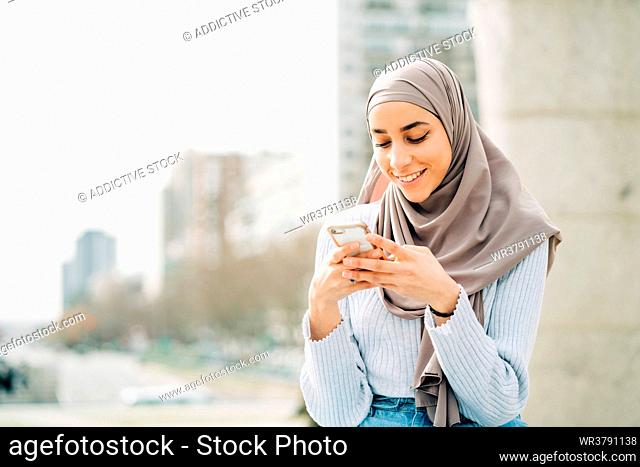 smiling, writing, smart phone, muslim