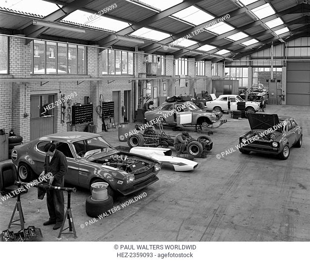 Modified Fords during race preparation, Littleborough, Greater Manchester, 1972. An early 1970s Ford Capri in a garage with three Ford Escorts being race...
