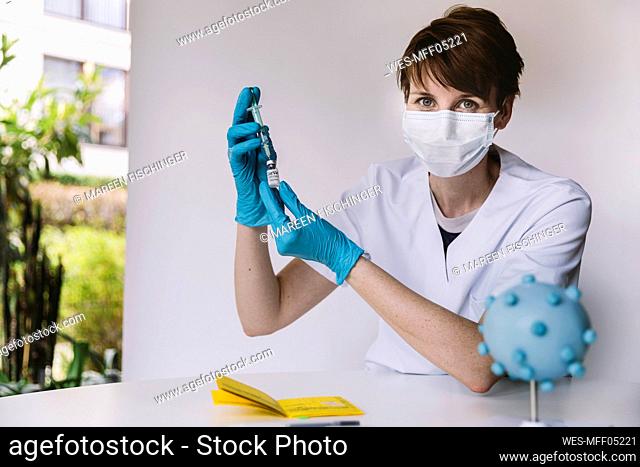 Portrait of doctor preparing injection with Corona virus vaccine