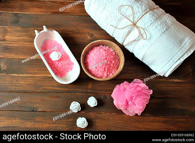 Spa and body care products. Aromatic rose bath Dead Sea Salt on the dark wooden background. Natural ingredients for homemade body salt scrub