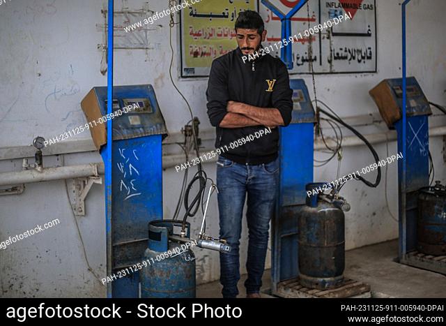 25 November 2023, Palestinian Territories, Khan Yunis: A Palestinian refills his liquid gas cylinder, on the second day of a four-day cease fire between Israel...