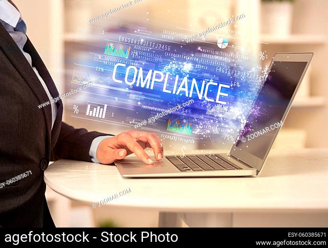 Closeup of businessman hands working on laptop with COMPLIANCE inscription, succesfull business concept