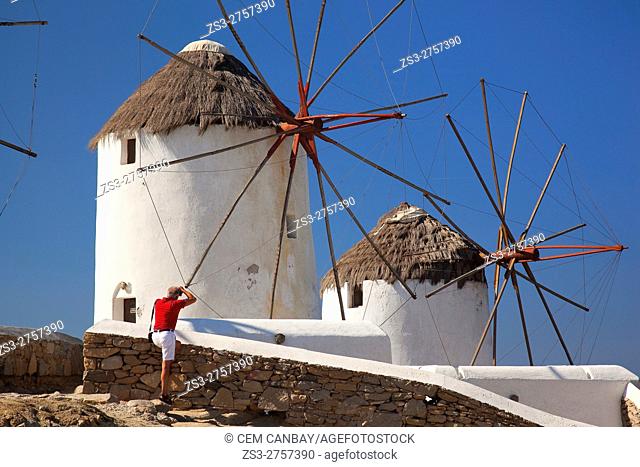 Tourist taking the photos of the traditional windmills, Mykonos, Cyclades Islands, Greek Islands, Greece, Europe