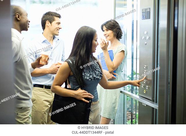 Business people riding glass elevator