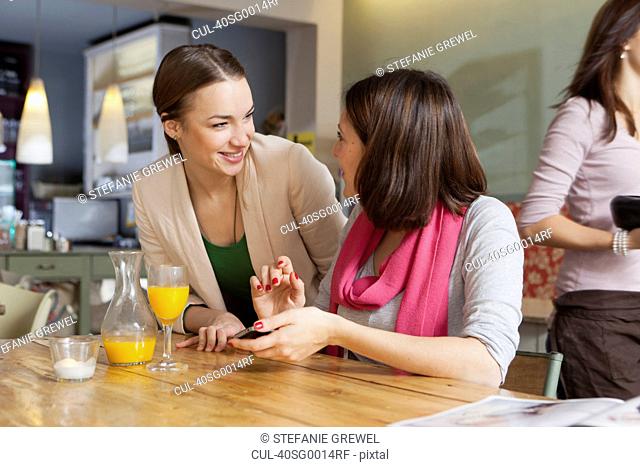Smiling women talking in cafe