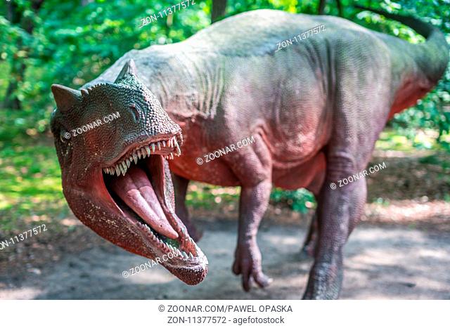 Solec Kujawski, Poland - August 2017 : Life sized Allosaurus dinosaur statue in a forest
