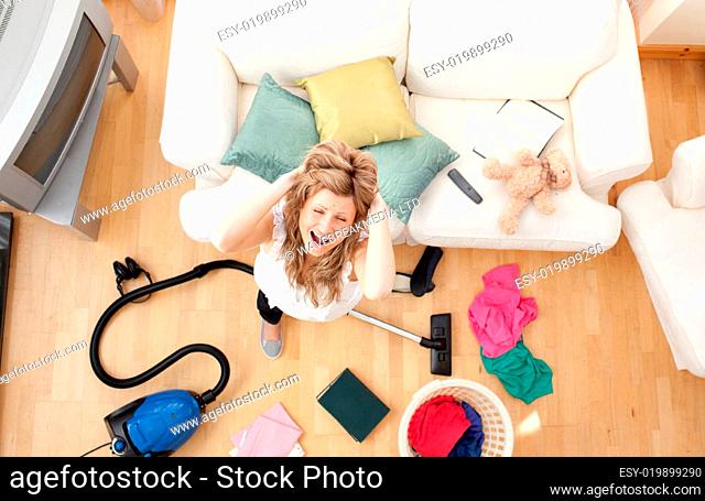 Stressed blond woman vacuuming the living-room