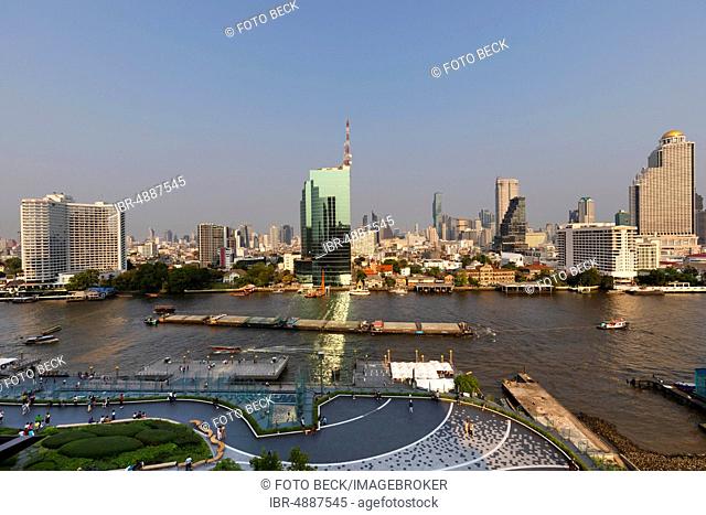 Panoramic view from Icon Siam, skyline with CAT building, tug with barges on Mae Nam Chao Phraya, Bang Rak district and Khlong San district in Thonburi, Bangkok