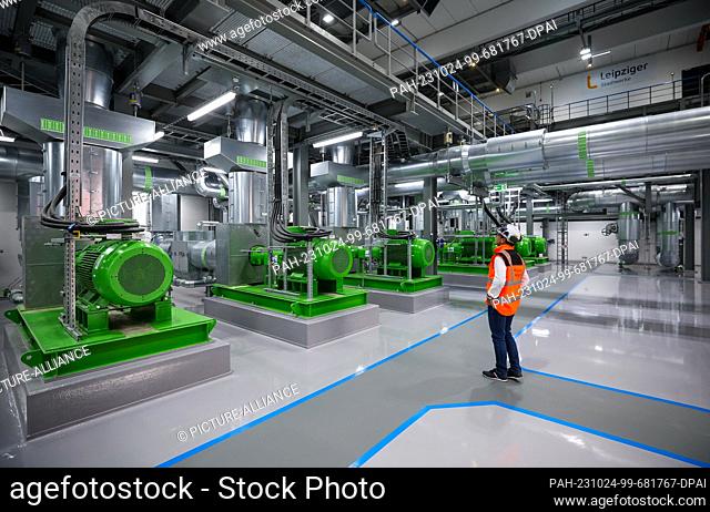 23 October 2023, Saxony, Leipzig: The power plant manager walks through the pump hall for district heating in the new combined heat and power plant South