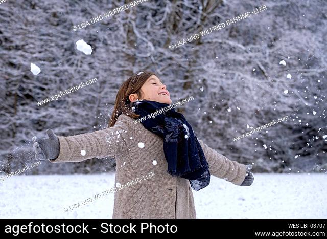 Happy girl in warm clothing enjoying snow