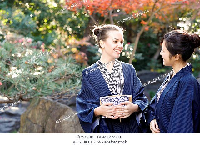 Caucasian woman wearing yukata with Japanese friend at traditional ryokan, Tokyo, Japan