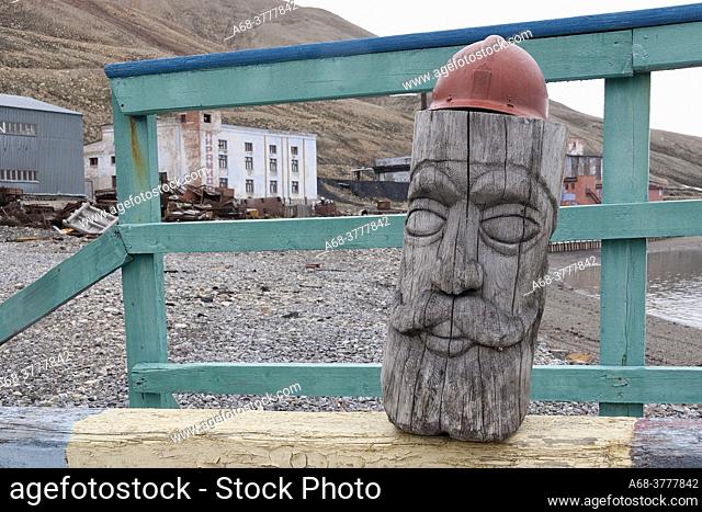 Carved old man. The abandoned Russian mining town of Piramida on Svalbard is visited almost every day by tourists who come there by ship from Longyearbyen
