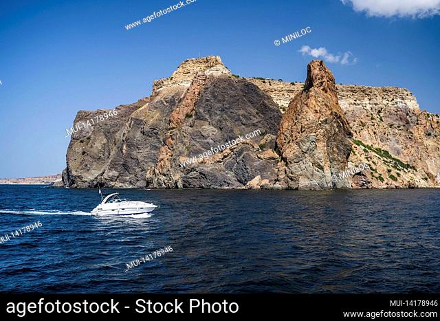 Pleasure tourist speed boat in black sea with volcanic rocks of Cape Fiolent in background, Sevastopol Crimea