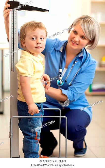 Doctor measuring boy's height in office