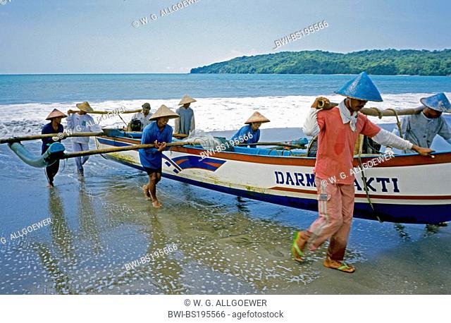 fishermen carrying a traditional fishing boat to the beach, Indonesia, Java