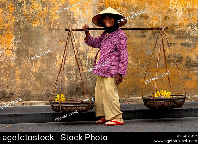 Old Woman from Vietnam is selling fruits in the Streets of Hoi An