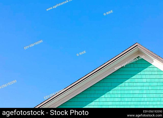 Colourful rooftop and blue sky. The traditional houses of the Magdalen Islands, Canada. Peppermint green, blue and white composition with space for text