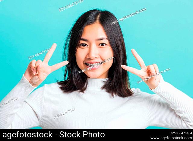 Portrait female give V-sign near-eye make Hollywood white smile, Young beautiful Asian woman showing peace gesture victory