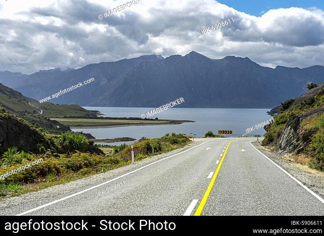 Road with views of mountains and Lake Hawea, The Neck, Otago, South Island, New Zealand, Oceania