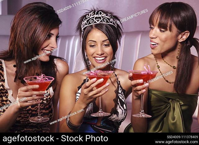 Multi-ethnic women drinking at bachelorette party