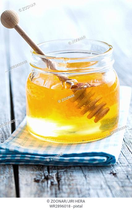 Wooden honey stick in jar