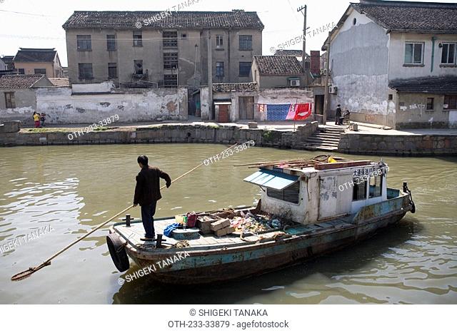 A boat at the canal Folk houses alongside, Suzhou, China