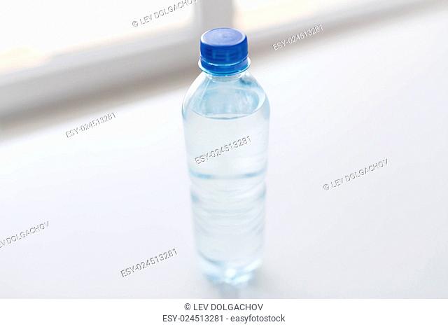 recycling, healthy eating and food storage concept - close up of plastic bottle with pure drinking water on table
