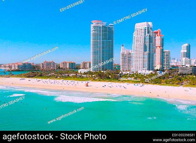 South Pointe Beach with surfers on boards waiting for the waves from the ocean, Miami, Florida, aerial view. Miami Beach. Aerial flight Miami waves