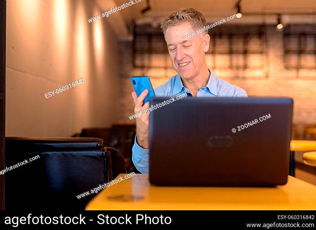Portrait of mature businessman sitting at the coffee shop indoors