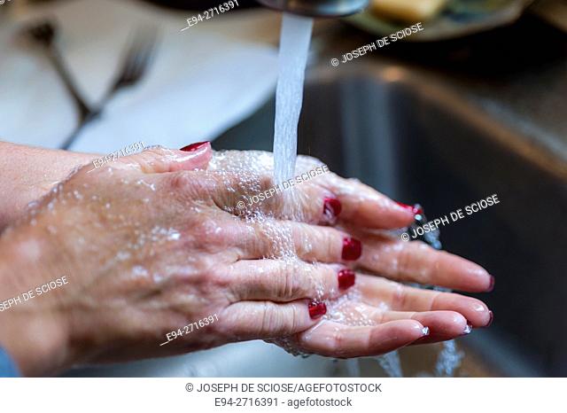 Woman's hands being washed over a sink