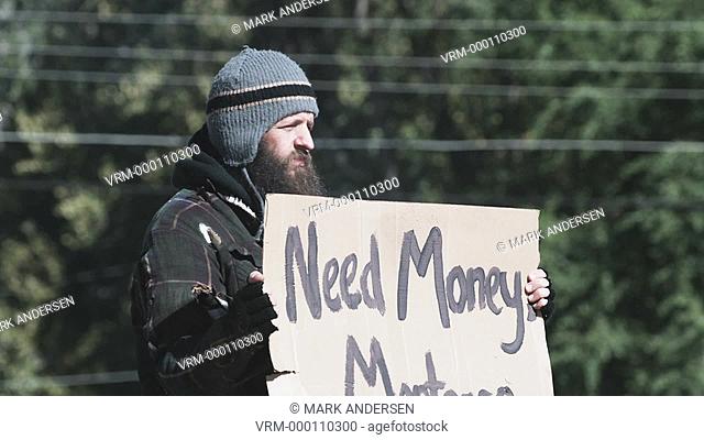homeless man holding a sign for money