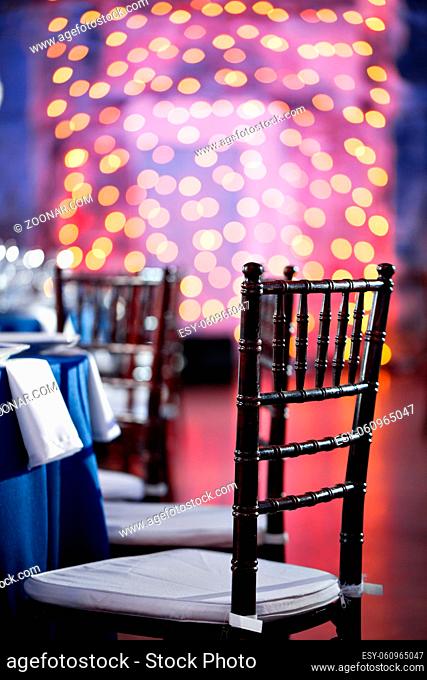 Wedding. Banquet. The chairs and table for guests, served with cutlery and crockery and covered with a blue tablecloth