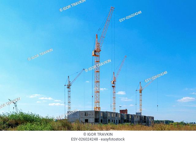 Several (four) tower cranes building a new multi-storey panel house