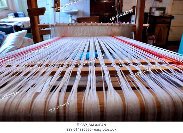Wooden loom with strings of cloth