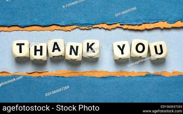 thank you word abstract in wooden letter cubes against paper abstract in blue tones, gratitude concept
