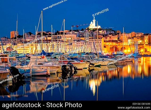 Marseille Old Port (Vieux-Port de Marseille) with yachts and Basilica of Notre-Dame de la Garde in the night. Marseille, France
