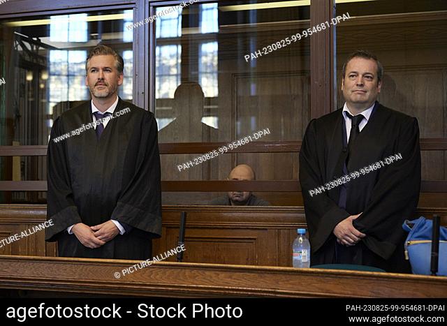25 August 2023, Berlin: An accused 55-year-old Russian sits between his defense attorneys Elvis Jochmann (l) and Piet Mumm in Room 700 of the Moabit Criminal...